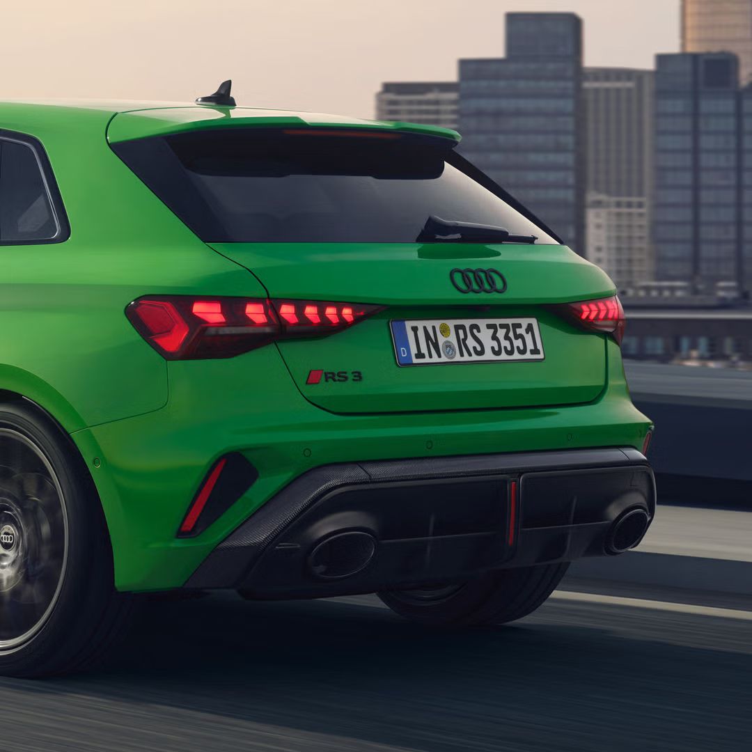 Nahaufnahme des Hecks des RS 3 Sportback von schräg hinten, im Hintergrund eine Skyline.